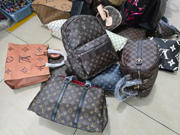 Police officers inspecting seized counterfeit goods during a raid in Bruma, Johannesburg.